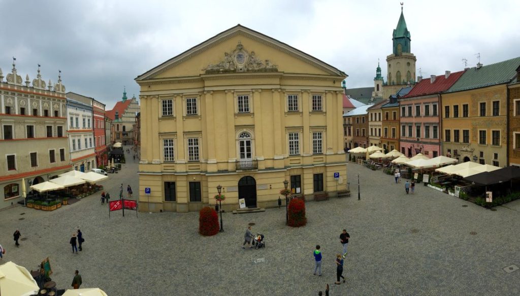 Lublin, Rynek Starego Miasta widok na dawny Ratusz tzw. Trybunał otoczony kamienicami. Widoczni spacerujący ludzie