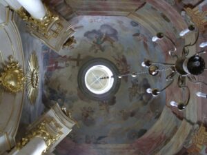 widoczne sklepienie kopuły kaplicy, na malowidłach widoczne postacie Aniołów