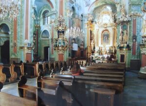 zdjęcie przedstawia wnętrze kościoła św. Anny, zdobienia na ścianach w centralnej części drewniane ławki, ołtarz główny i ambona