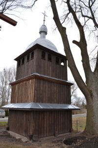 widok na drewnianą odnowioną dzwonnicę, dach pokryty blachą.